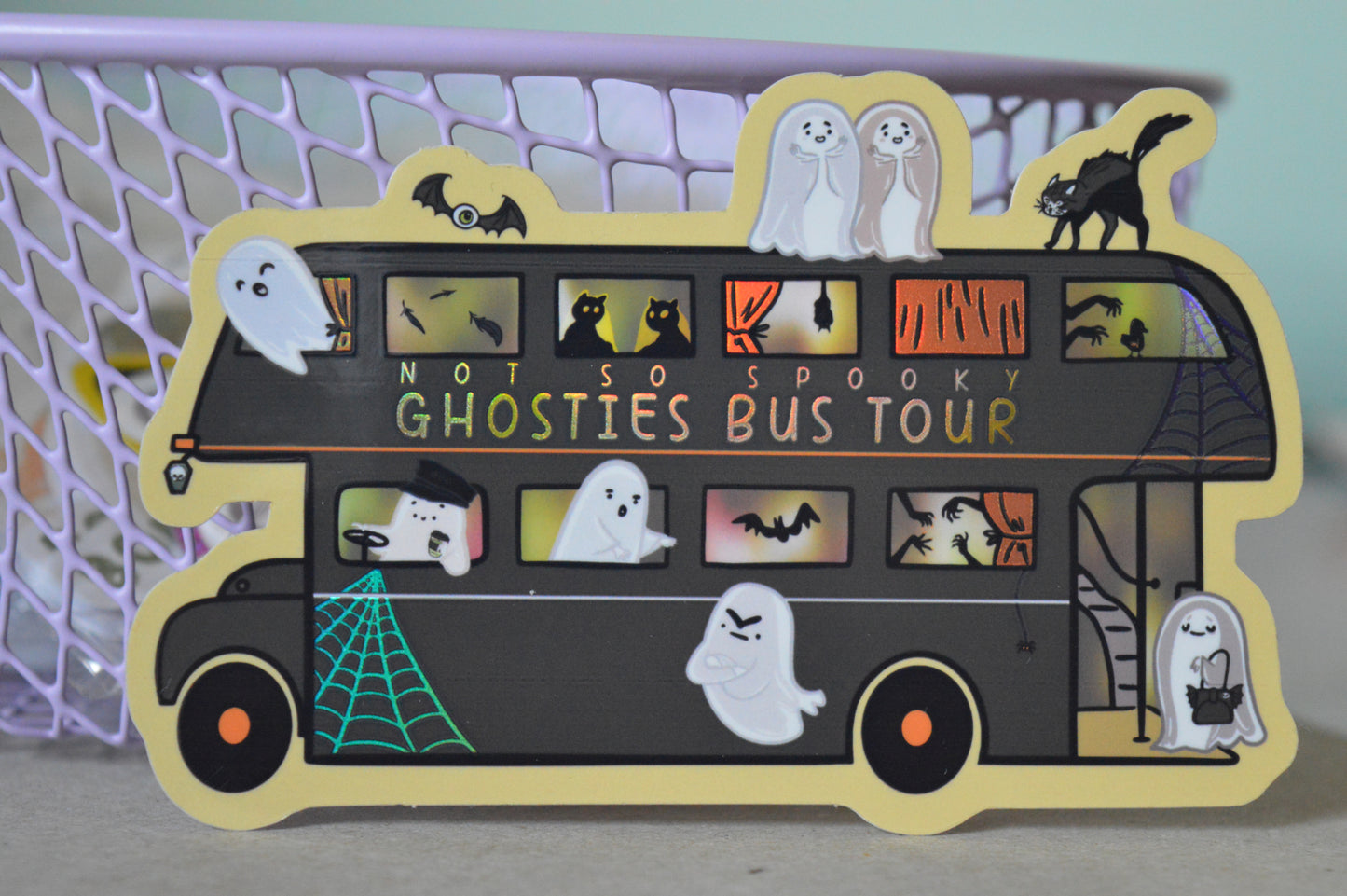 Halloween-themed bus sticker with ghosts, cats, and other spooky creatures