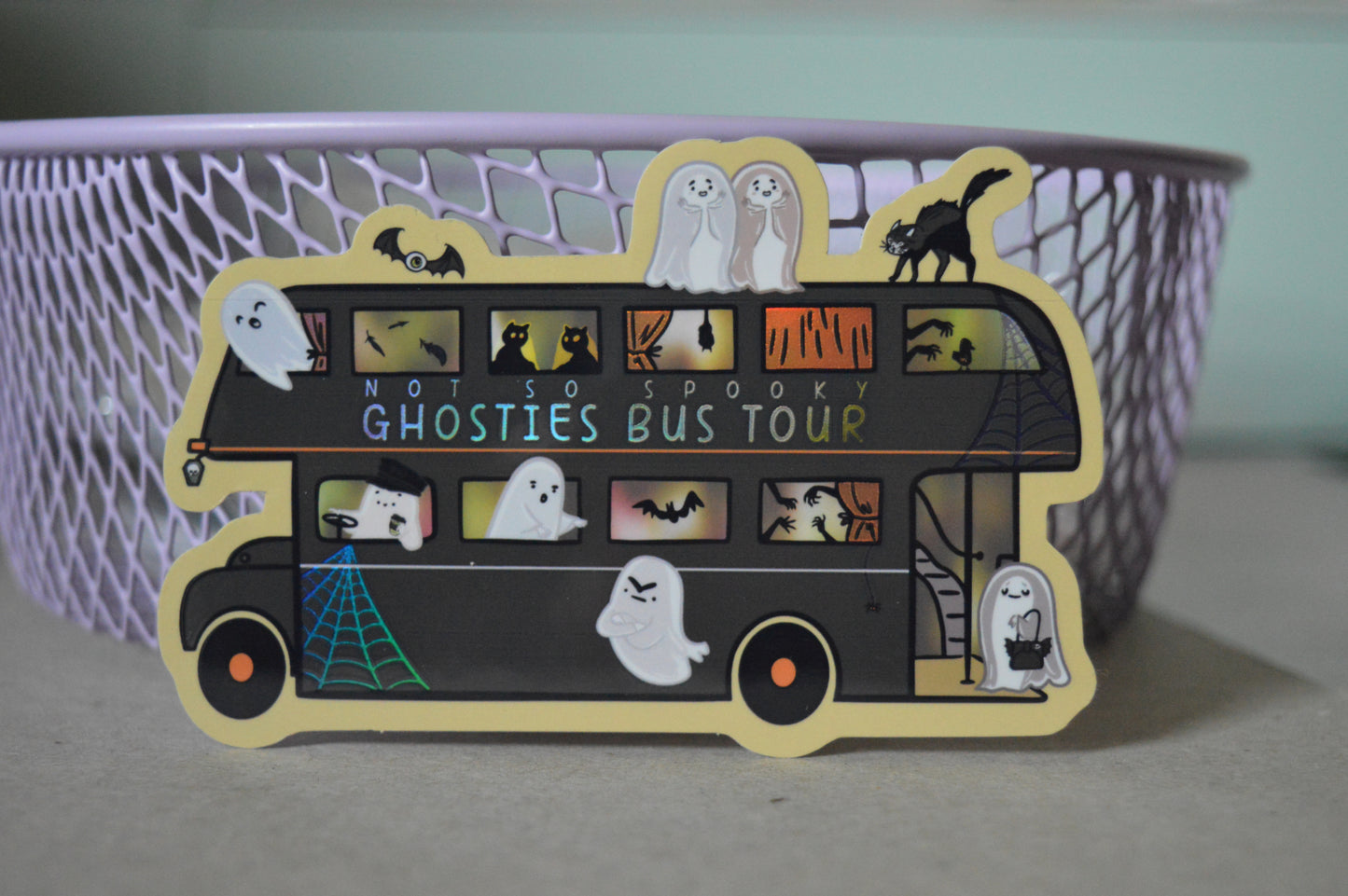 Halloween-themed sticker of a bus with ghosties and other spooky creatures