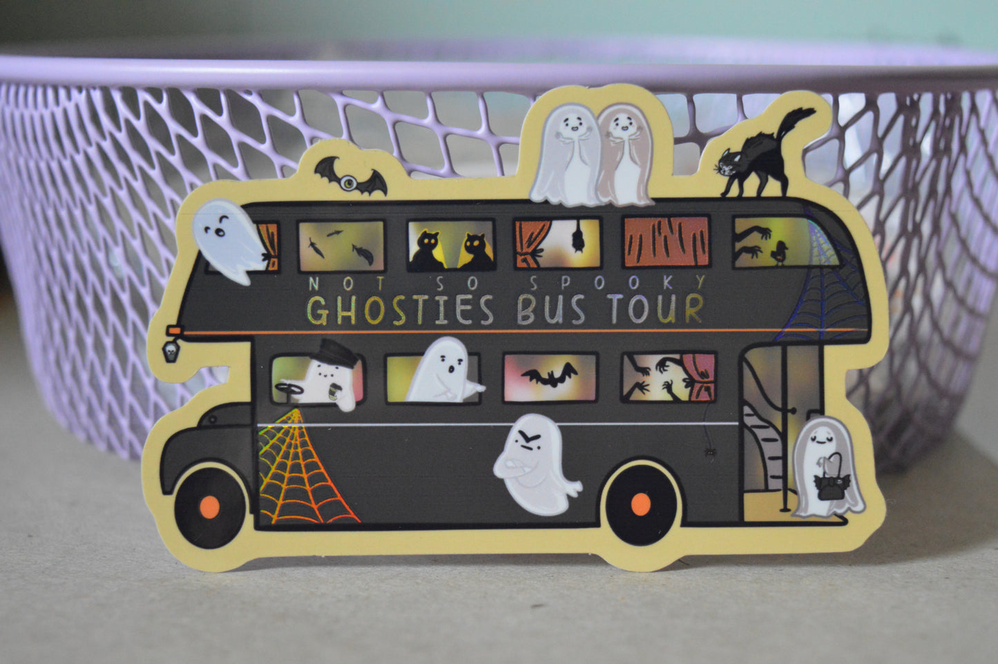 Halloween-themed sticker of a bus with ghosties and spooky elements