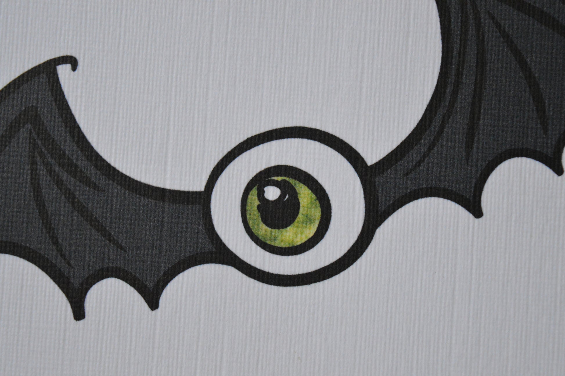 Bat wings with a large green eye in the centre