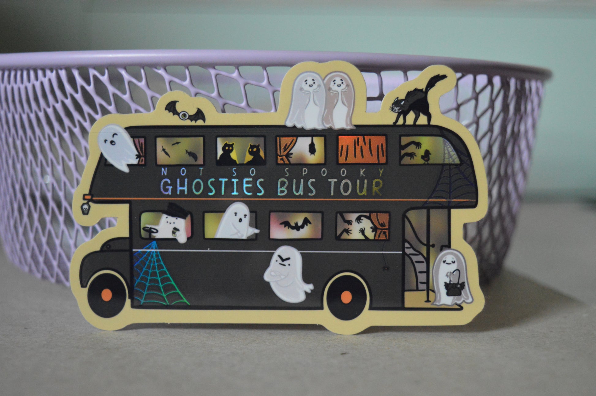 Halloween-themed sticker of a bus with ghosties and other spooky creatures